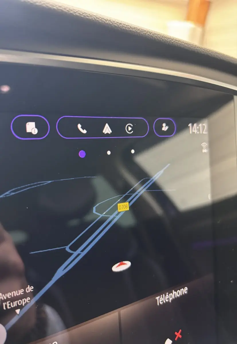 Écran tactile central affichant la navigation dans une Renault Mégane bleu, vue rapprochée intérieure.