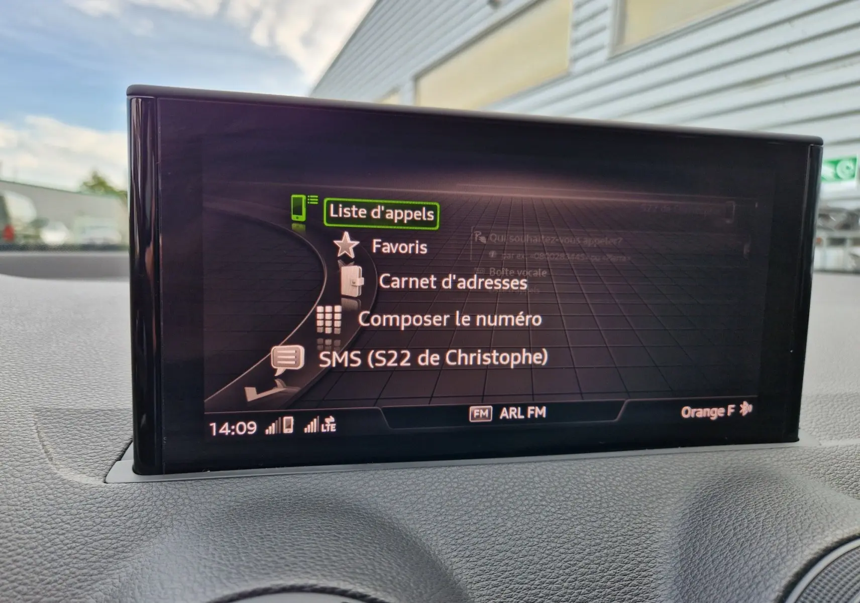 Écran central de l'Audi Q2 35 TFSI 2023 affichant la liste d'appels avec interface connectée, vue intérieure frontale.