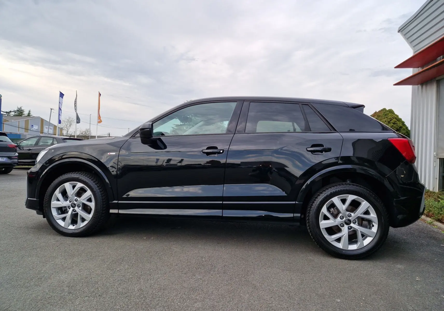 Audi Q2 35 TFSI noir mito metal vue de profil côté gauche, avec jantes alliage et lignes épurées.