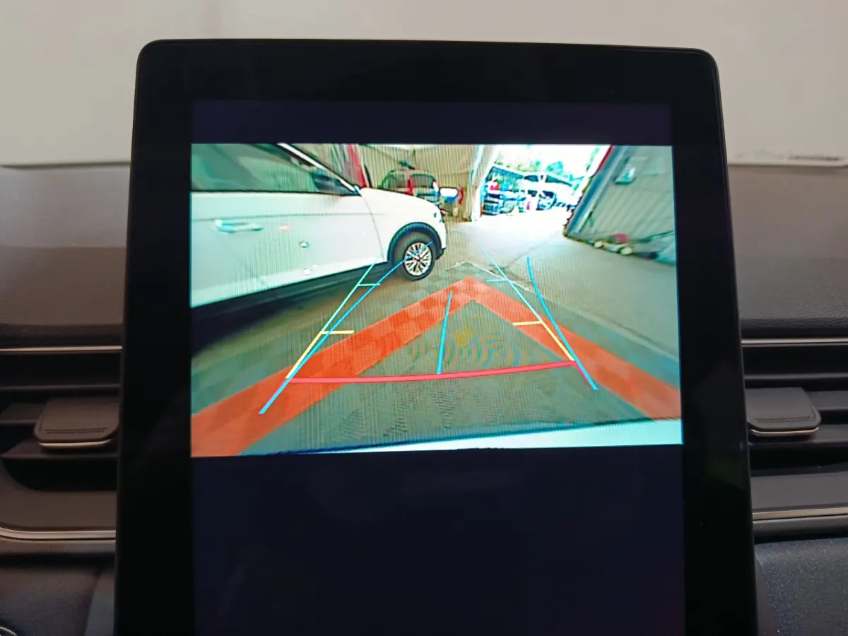 Écran tactile central montrant la caméra de recul avec un SUV blanc Renault Captur côté gauche en stationnement.