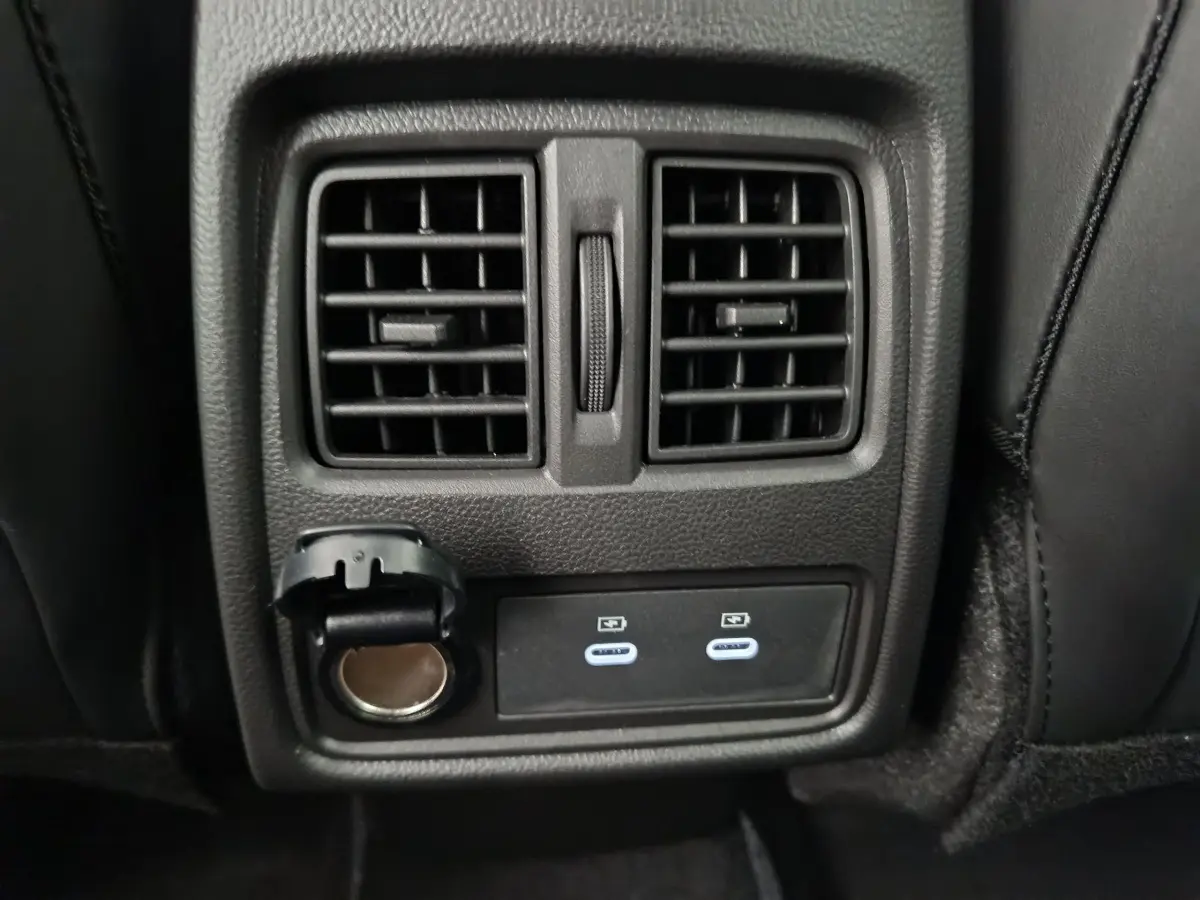 Prise USB double et prise 12V sous les aérateurs arrière noirs du Renault Captur blanc techno E-Tech 2025.