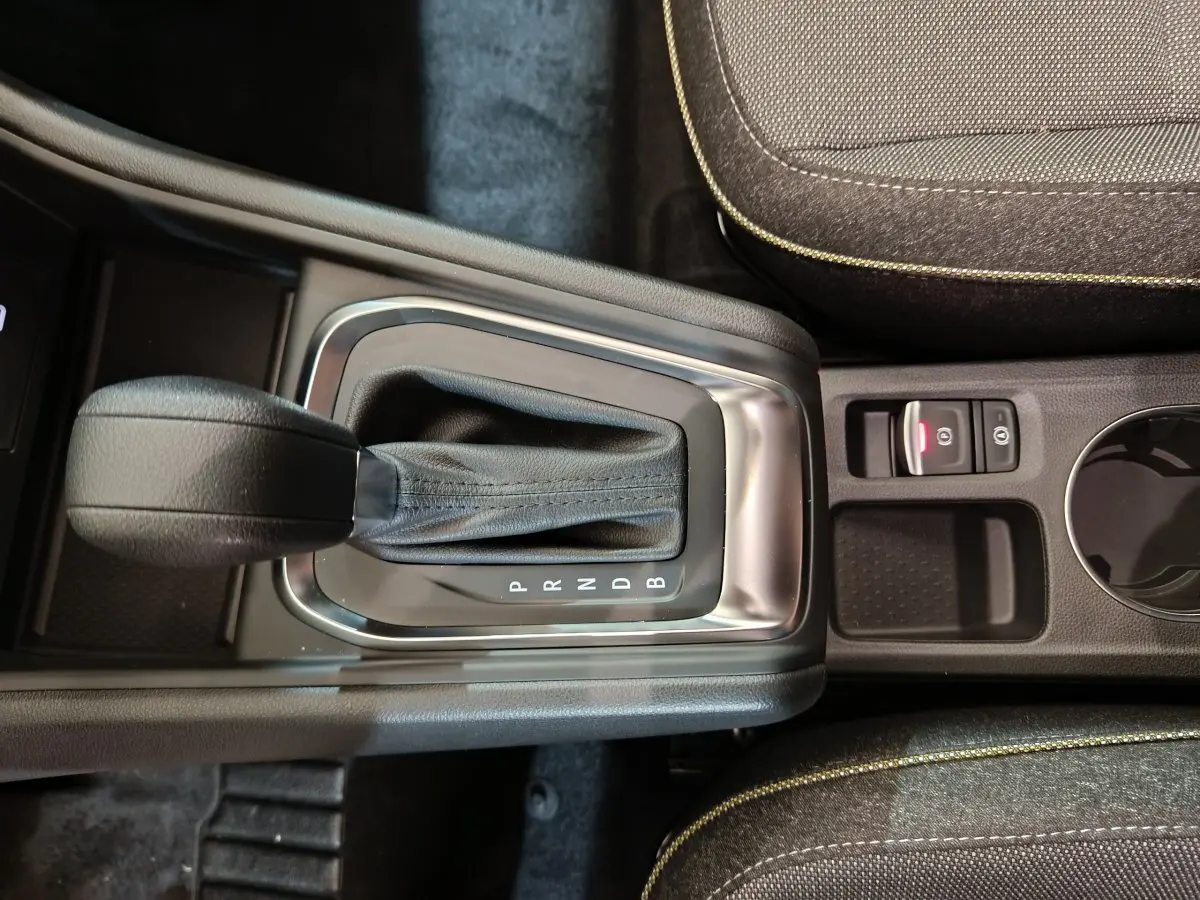 Vue rapprochée de la console centrale du Renault Captur blanc 2025, avec levier de boîte automatique et frein électrique.