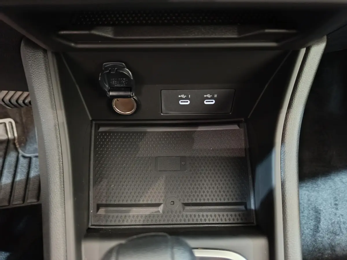 Vue rapprochée de la console centrale noire du Renault Captur blanc 2025 avec prises USB-C et prise 12V ouverte.