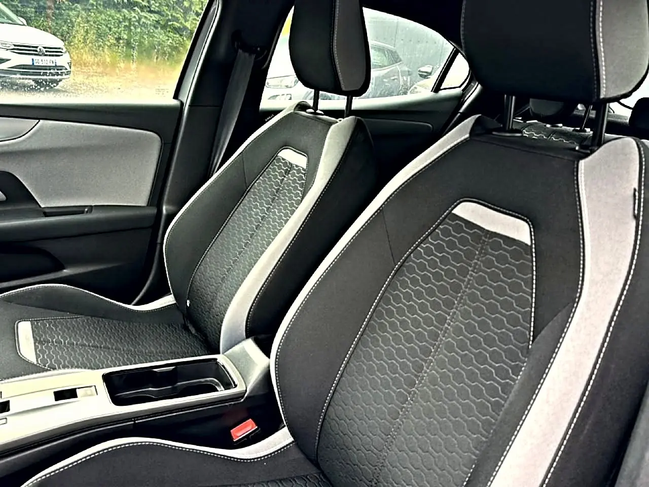Vue intérieure rapprochée des sièges avant gris foncé et clair de l’Opel Mokka 2025 avec console centrale visible.