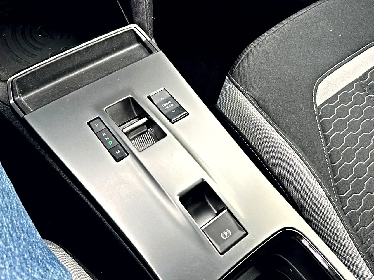 Vue rapprochée de la console centrale grise avec levier de vitesses automatique et siège tissu noir Opel Mokka 2025.