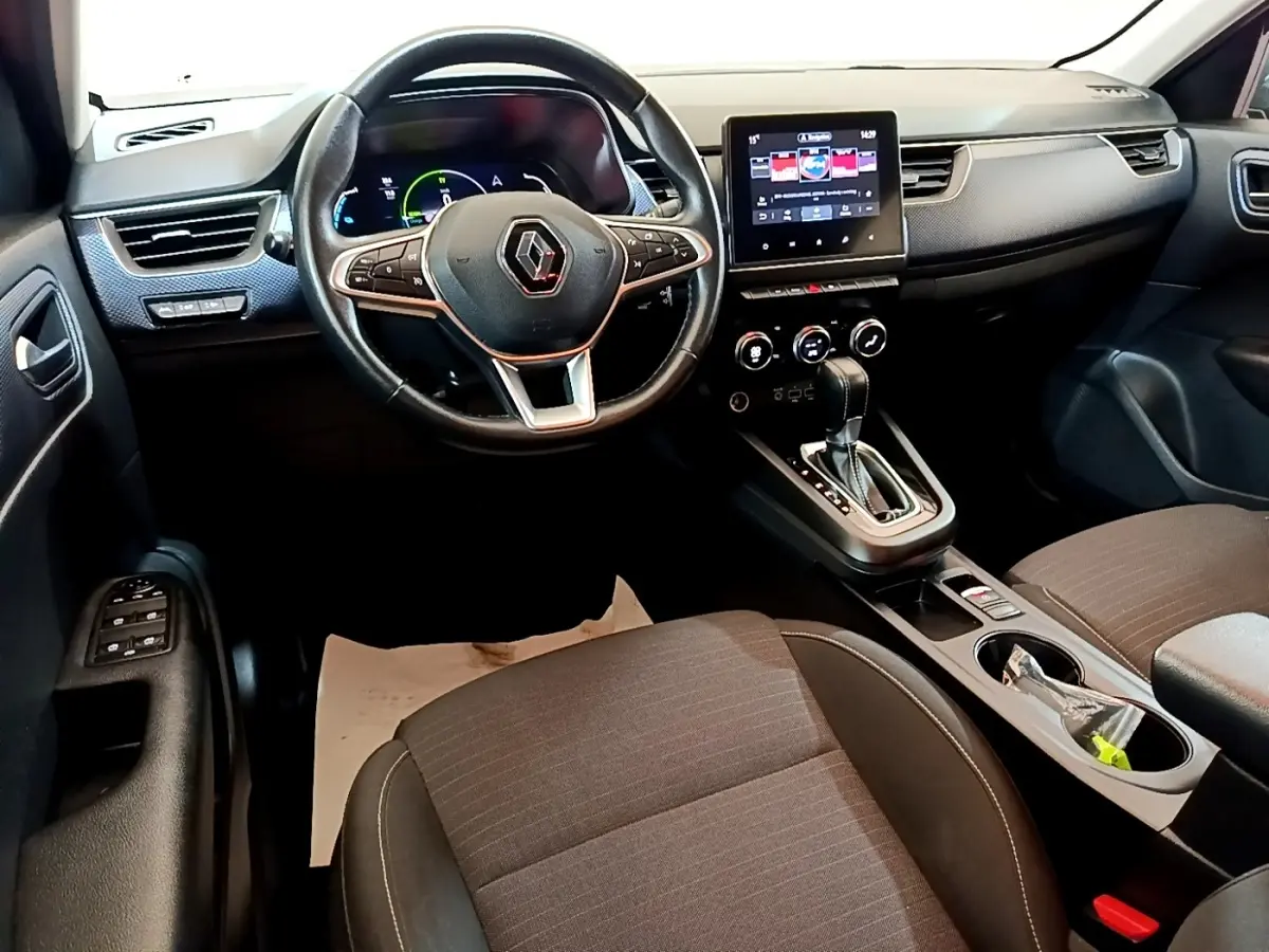 Vue intérieure avant du Renault Arkana Business E-TECH 145, tableau de bord noir avec écran tactile central et volant multifonctions.