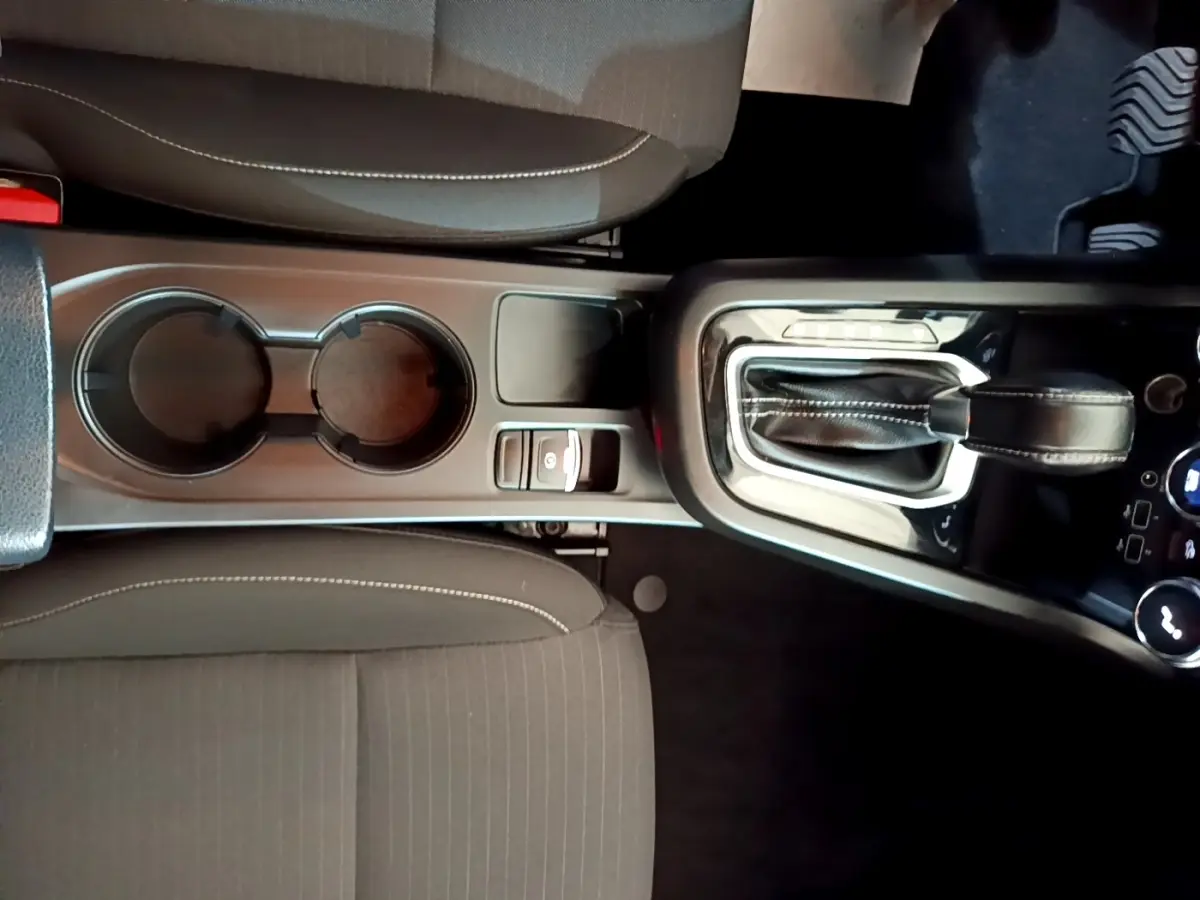 Vue plongeante sur la console centrale du Renault Arkana Business E-TECH 145, avec levier de vitesse et porte-gobelets.