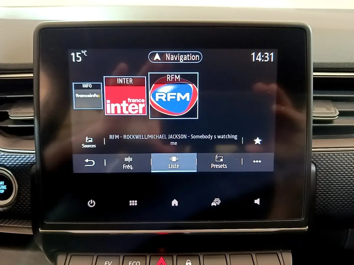 Écran tactile central du tableau de bord du Renault Arkana Business E-TECH 145 affichant la radio et la navigation.