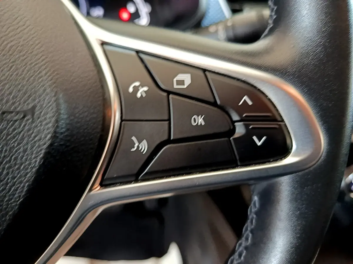 Gros plan sur les commandes multifonctions du volant en cuir noir du Renault Arkana Business E-TECH 145 2022.