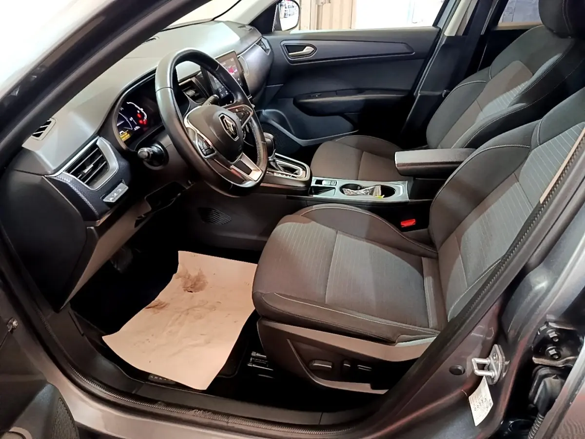 Intérieur avant droit du Renault Arkana Business E-TECH 145 gris foncé, avec volant multifonctions et console centrale moderne.