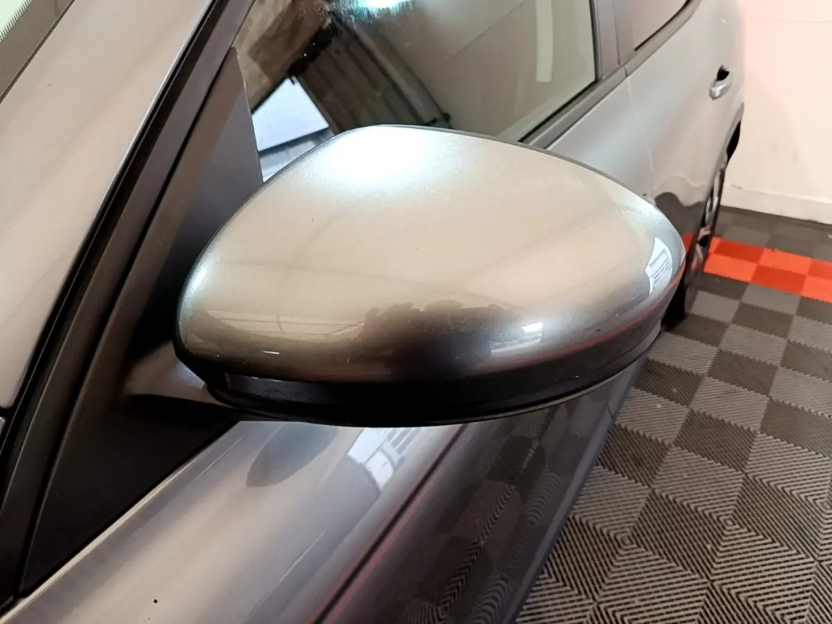 Rétroviseur côté conducteur gris foncé du Renault Arkana Business E-TECH 145 vu en gros plan depuis l'avant gauche.