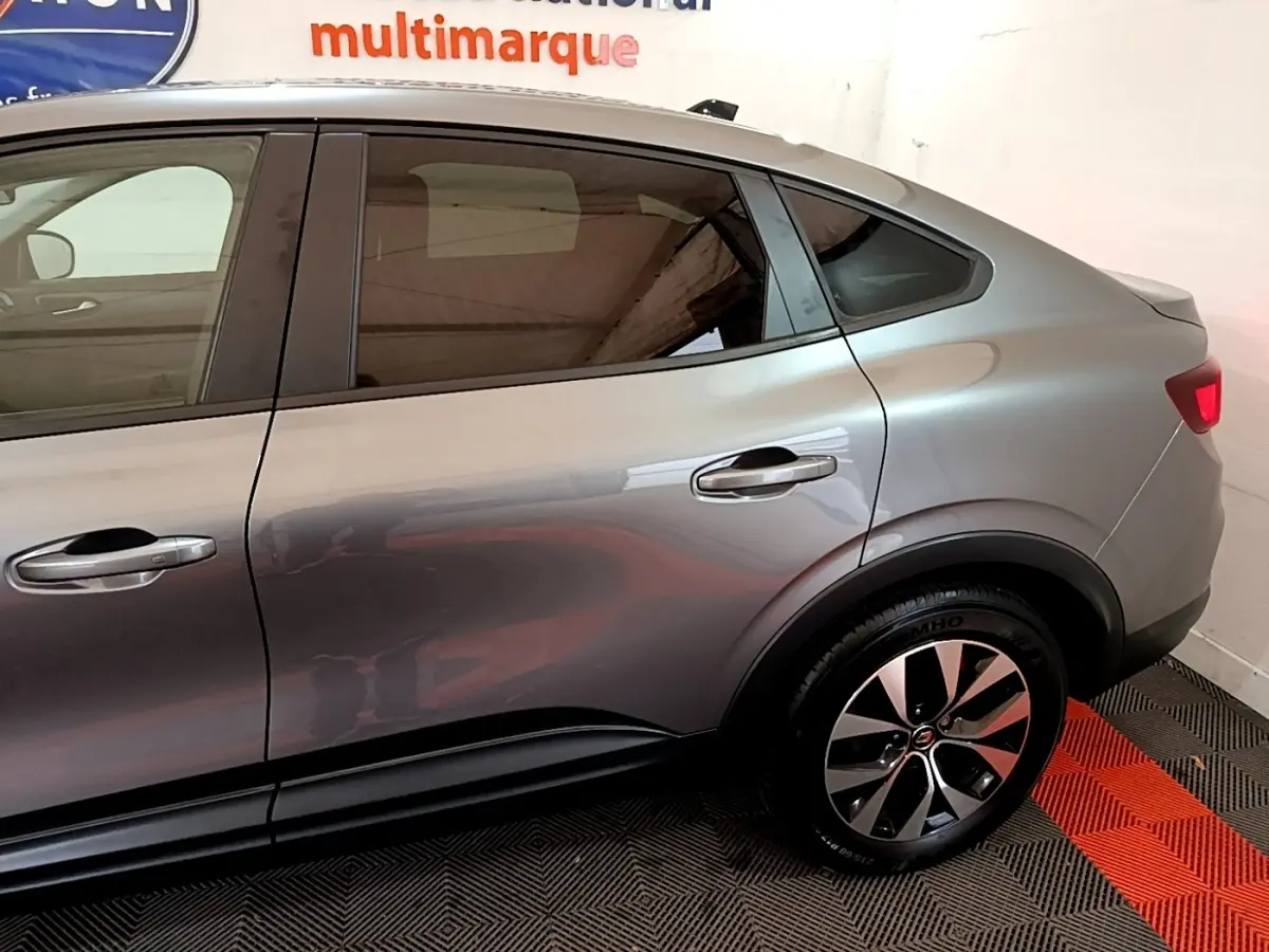 Profil côté droit du Renault Arkana Business E-TECH 145 gris foncé, mettant en valeur ses lignes fluides et la jante alliage distinctive.