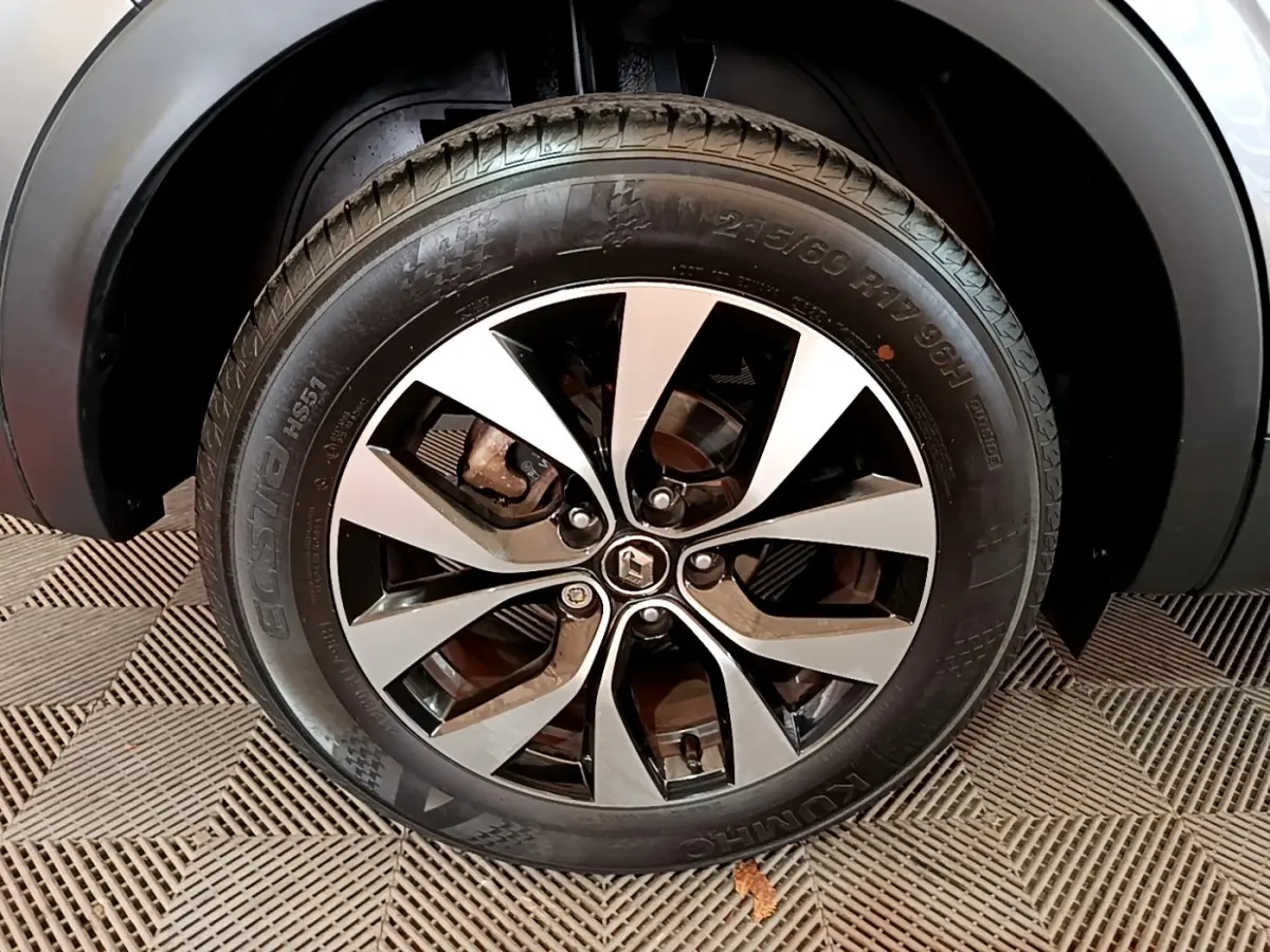 Gros plan sur la roue avant droite du Renault Arkana Business E-TECH 145 gris foncé avec jante alliage bicolore.