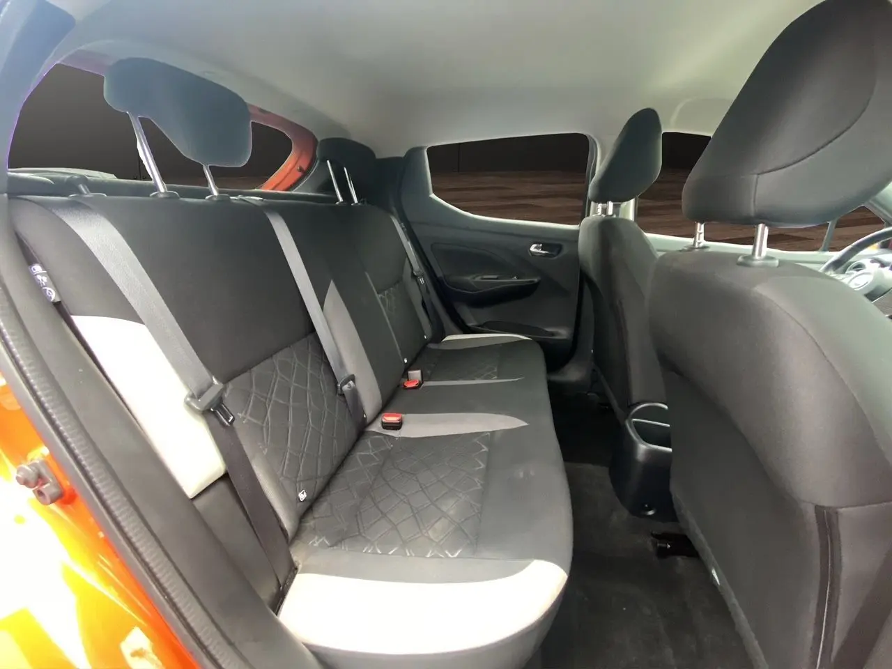 Vue intérieure côté gauche des sièges arrière noirs et beige d'une Nissan Micra orange Energy 2022, finition N-Design.