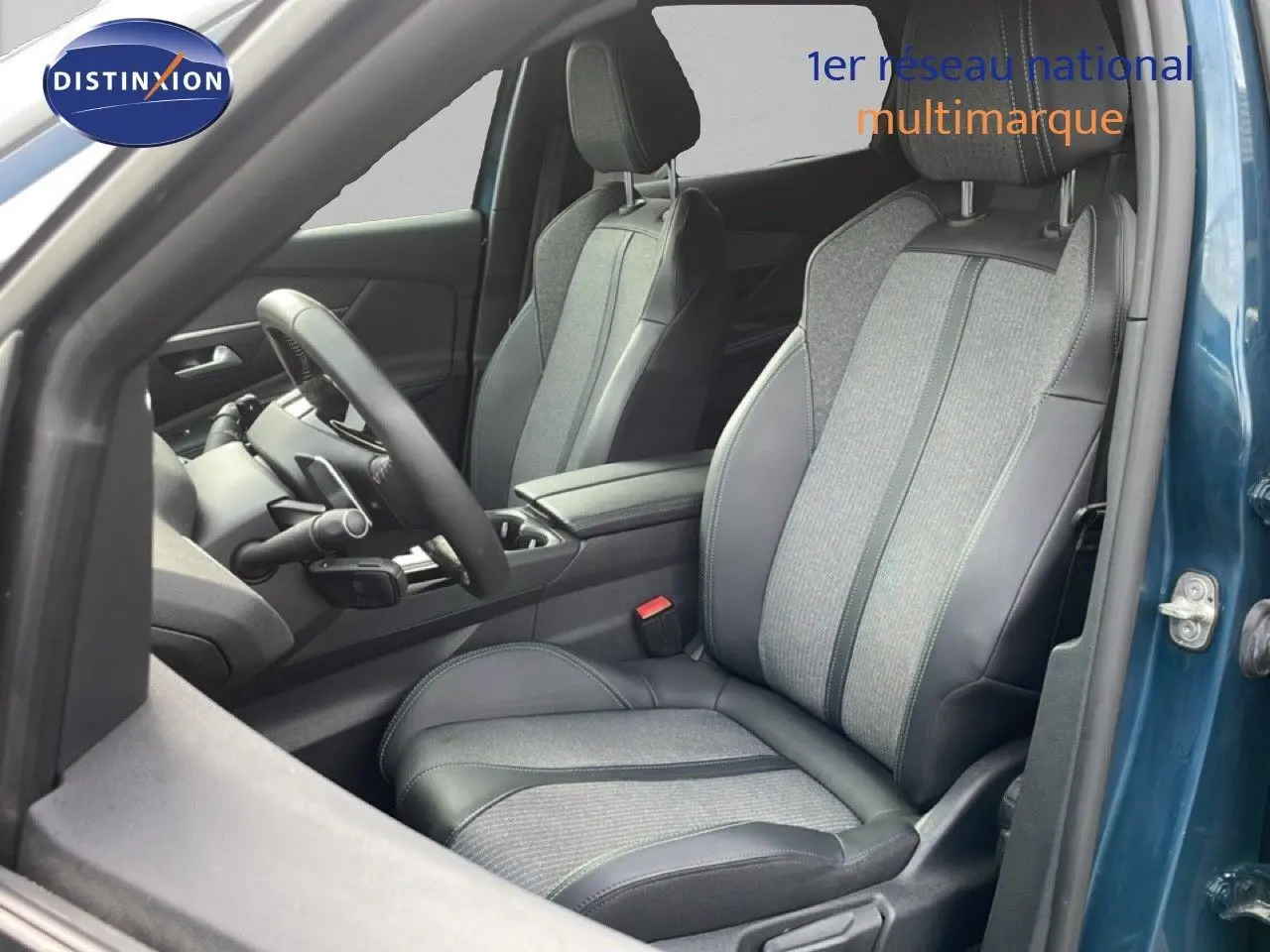 Vue intérieure côté conducteur du Peugeot 3008 bleu Celebes, sièges bi-matière tissu et cuir gris avec surpiqûres bleues.
