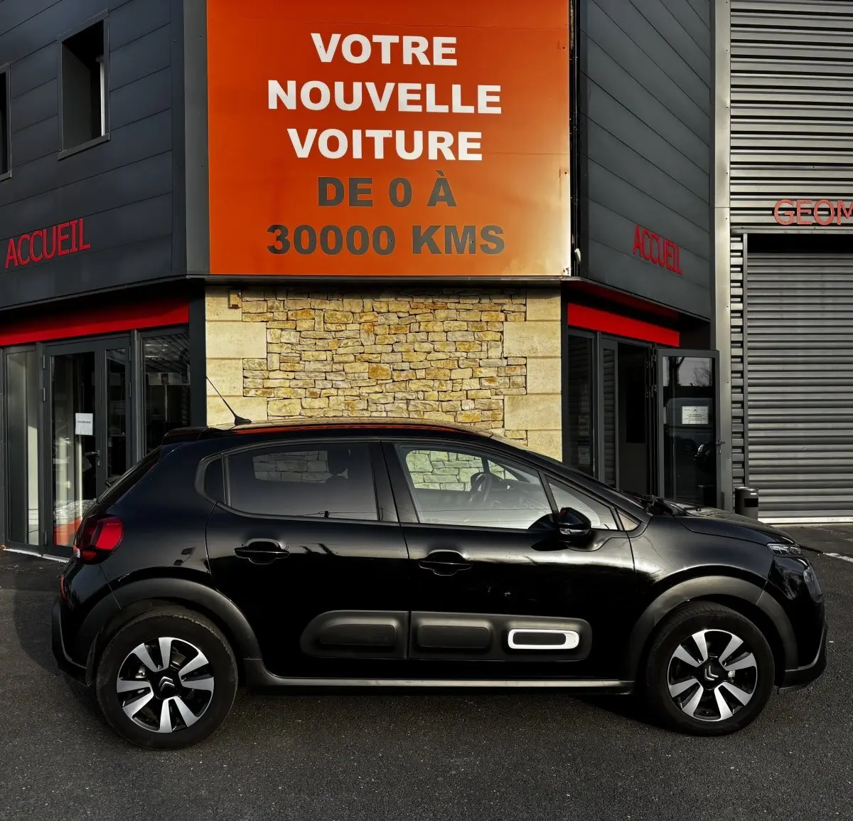 Vue de profil côté gauche d'une Citroën C3 noire 2024 avec protections latérales distinctives et jantes bicolores.