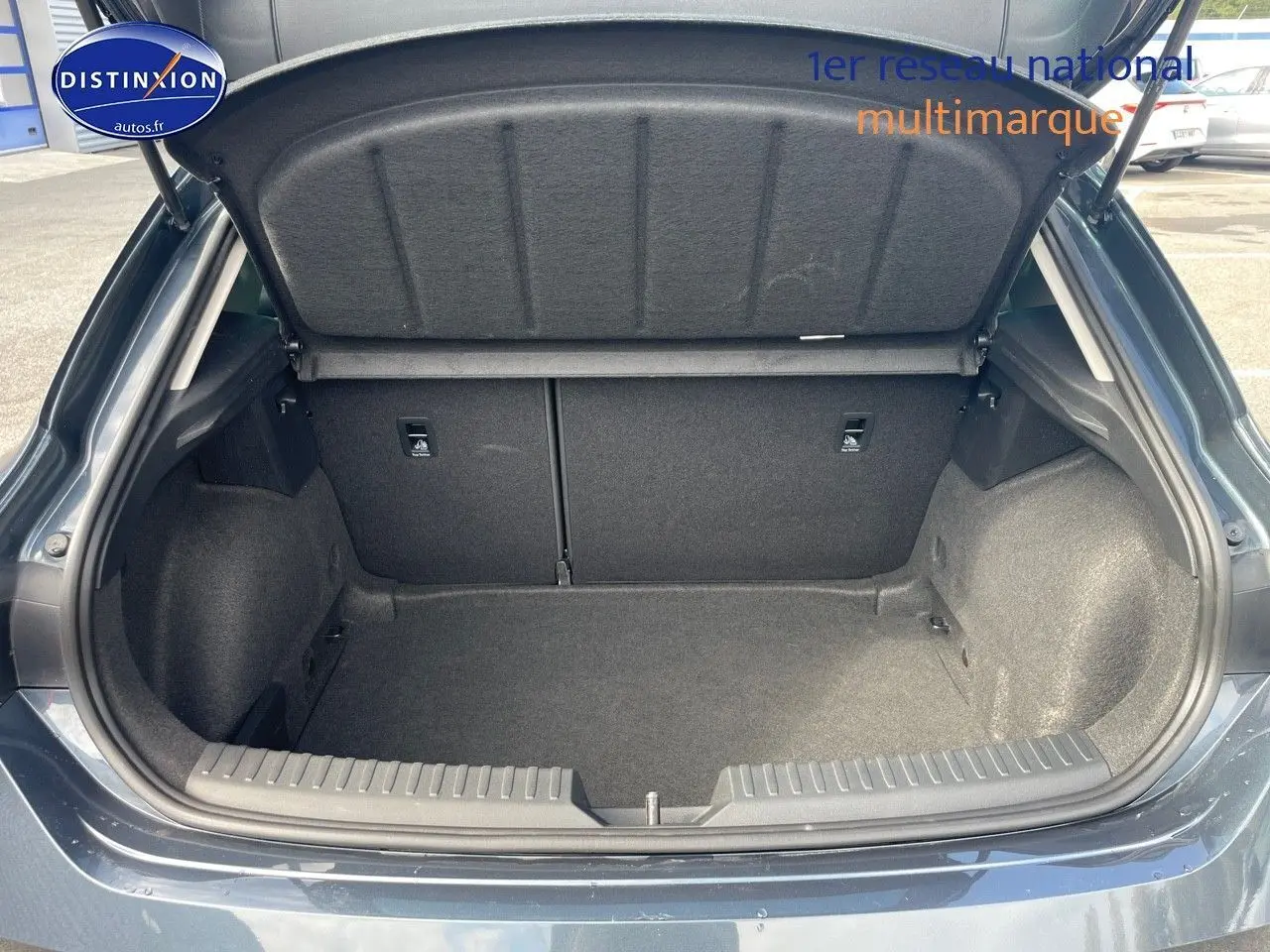 Coffre ouvert vu de l'arrière d'une SEAT LEON IV gris magnétique métal, montrant un espace de chargement propre et spacieux.