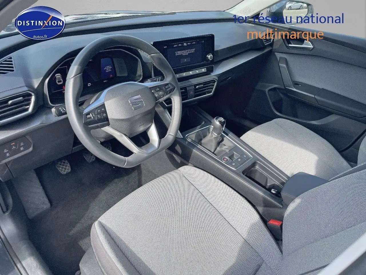 Intérieur avant de la SEAT LEON IV 1.5 TSI gris avec tableau de bord moderne et boîte manuelle visible entre les sièges.