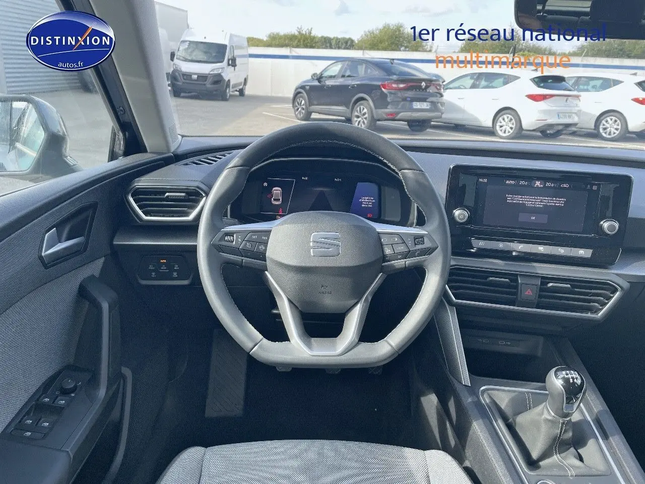 Vue intérieure du tableau de bord et volant de la SEAT LEON IV gris magnétique avec boîte manuelle et écran tactile central.