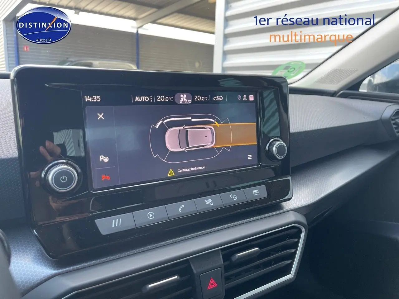 Vue rapprochée de l'écran tactile central du tableau de bord de la SEAT LEON gris magnétique, affichant l'aide au stationnement.