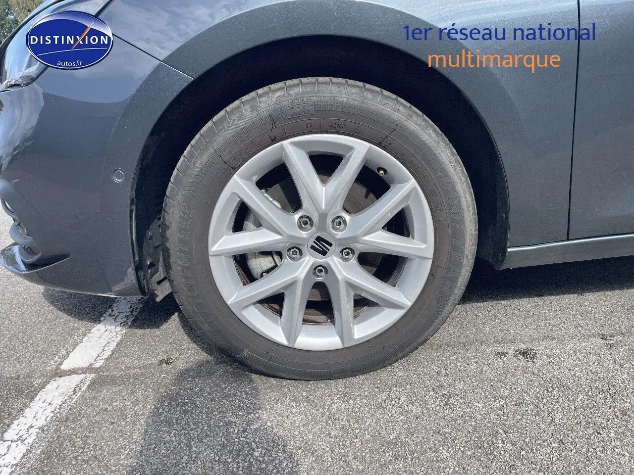 Gros plan sur la roue avant gauche d'une SEAT LEON gris magnétique métal avec jante alliage 16 pouces.