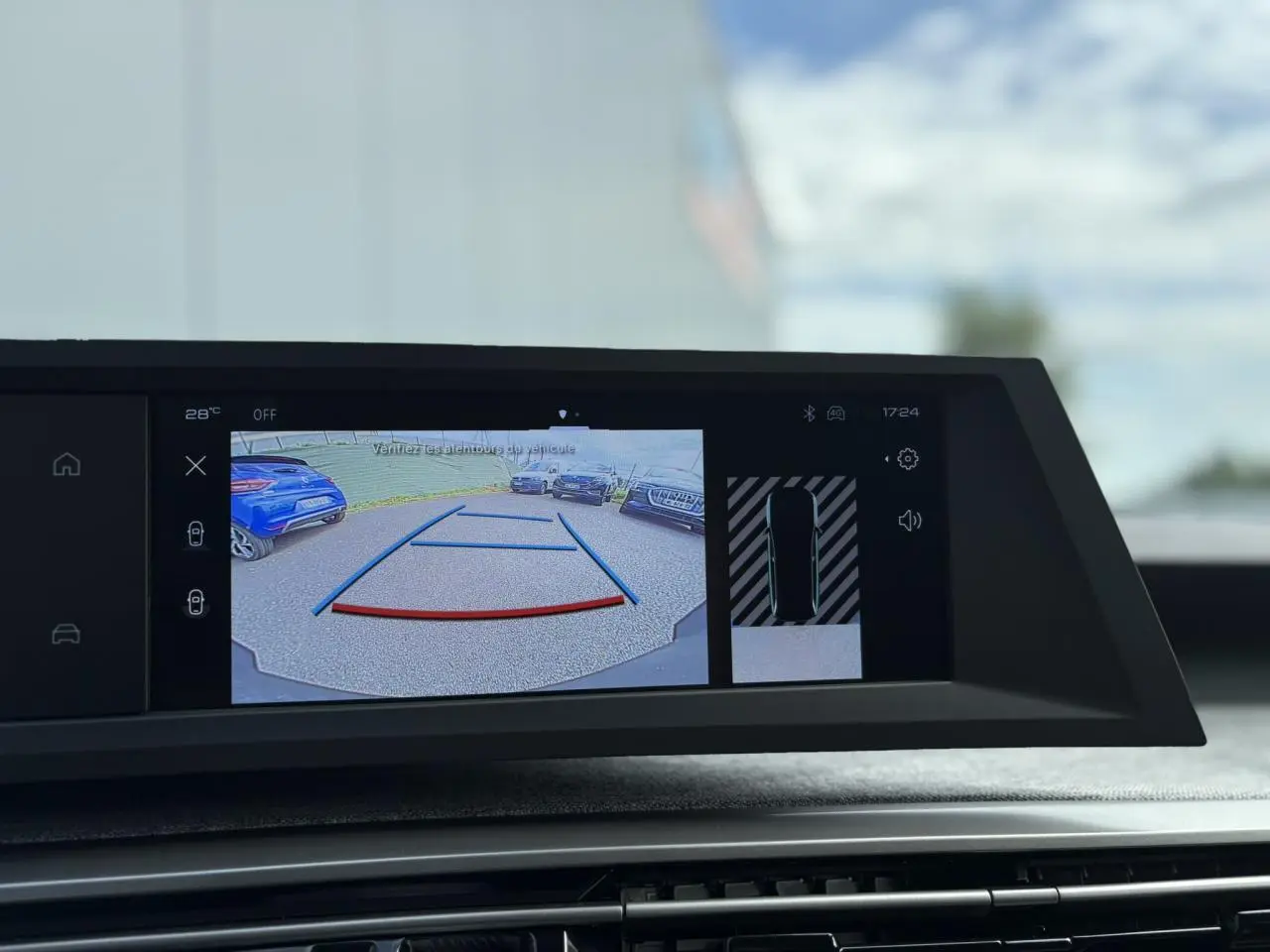 Écran central du Peugeot 5008 Hybrid blanc montrant la caméra de recul avec lignes de guidage et vue périphérique.