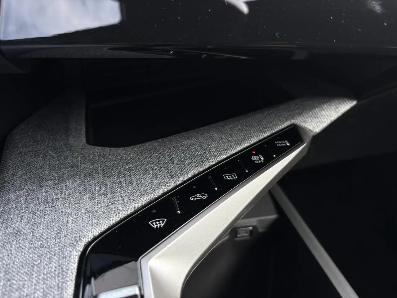 Détail du panneau de commandes climatisation avec finition tissu gris dans l'habitacle du Peugeot 5008 blanc.