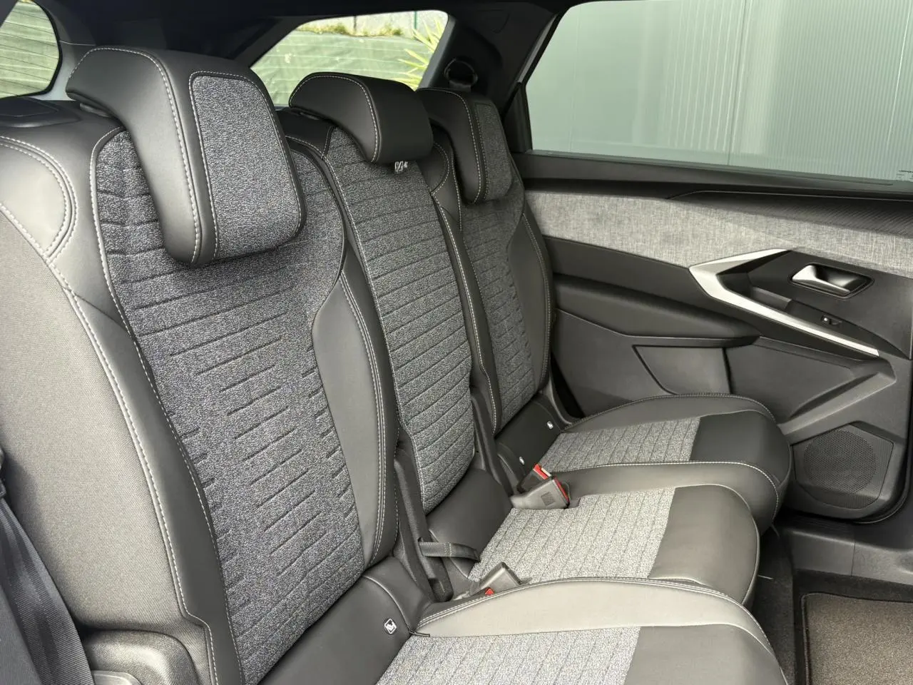 Vue latérale droite des sièges arrière en tissu gris et cuir noir du Peugeot 5008 Hybrid 145 e-DSC6 Allure 2025.