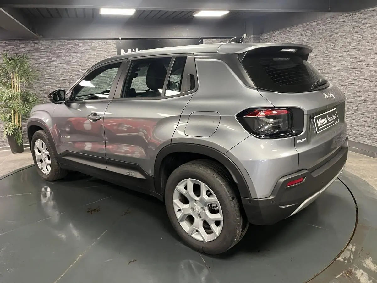 Vue 3/4 arrière droite d'un Jeep Avenger gris métallisé avec jantes alliage 17 pouces et feux arrière noirs.