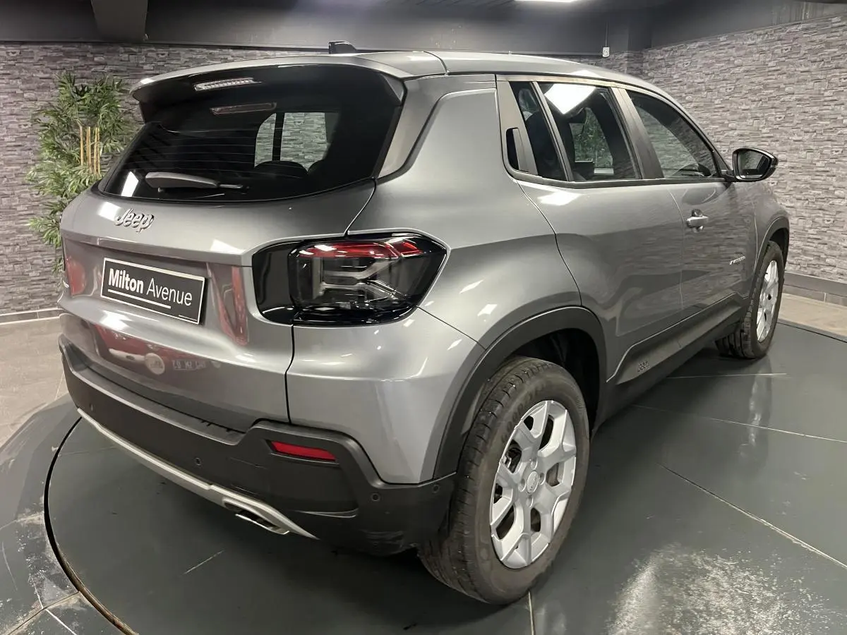 Vue 3/4 arrière droite du Jeep Avenger gris métallisé avec feux arrière sombres et jantes alliage 17 pouces.