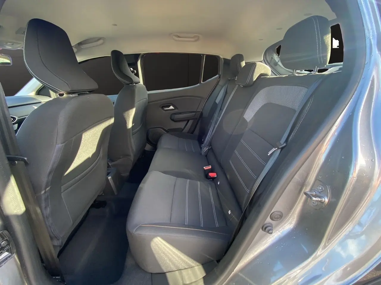 Vue intérieure côté droit sur les sièges arrière noirs du Dacia Sandero Stepway 2025 gris schiste.