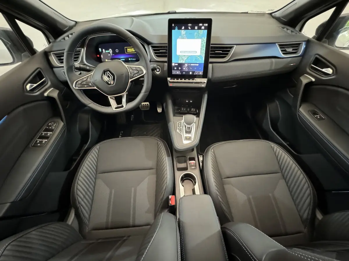 Intérieur noir du Renault Captur esprit Alpine E-Tech 2025, vue frontale sur tableau de bord et sièges avant.