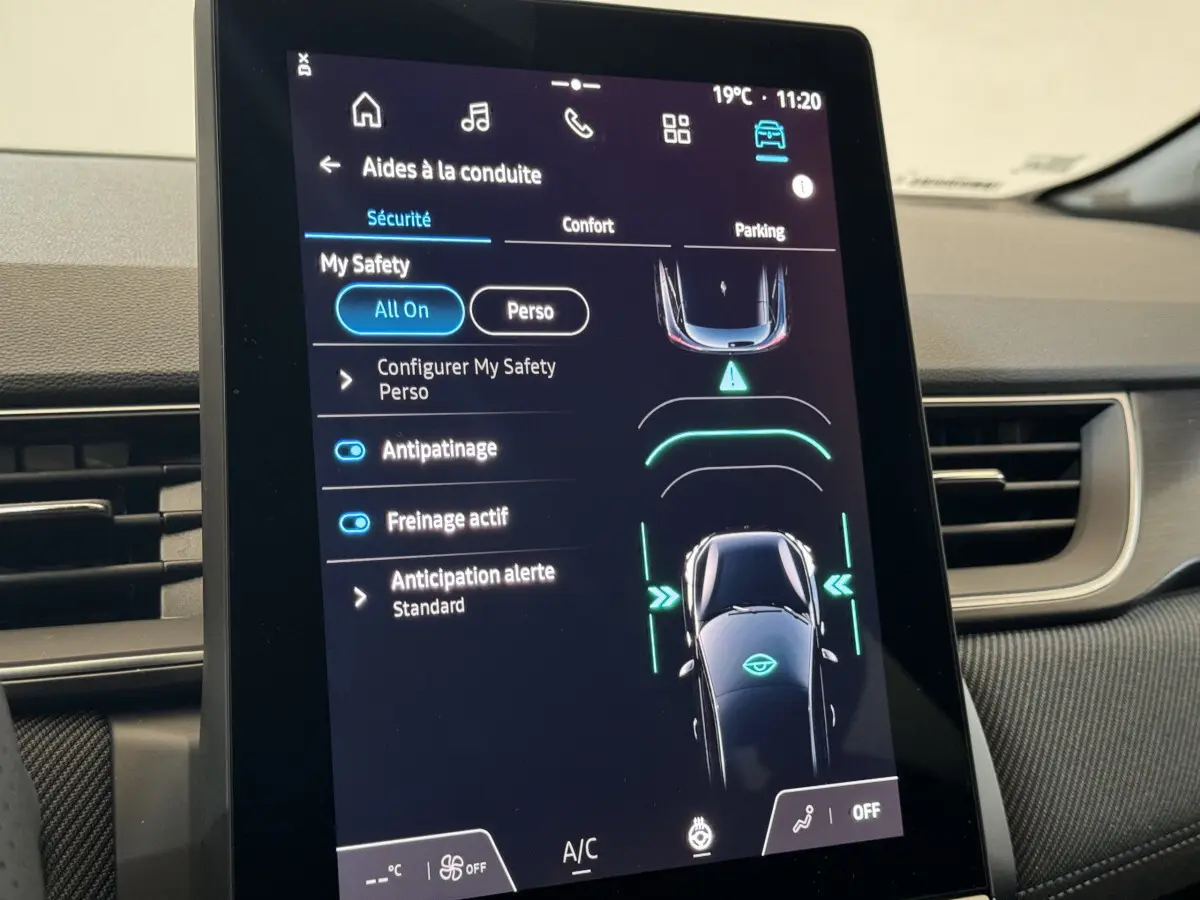 Écran tactile central du Renault Captur blanc 2025 montrant les aides à la conduite et réglages de sécurité.