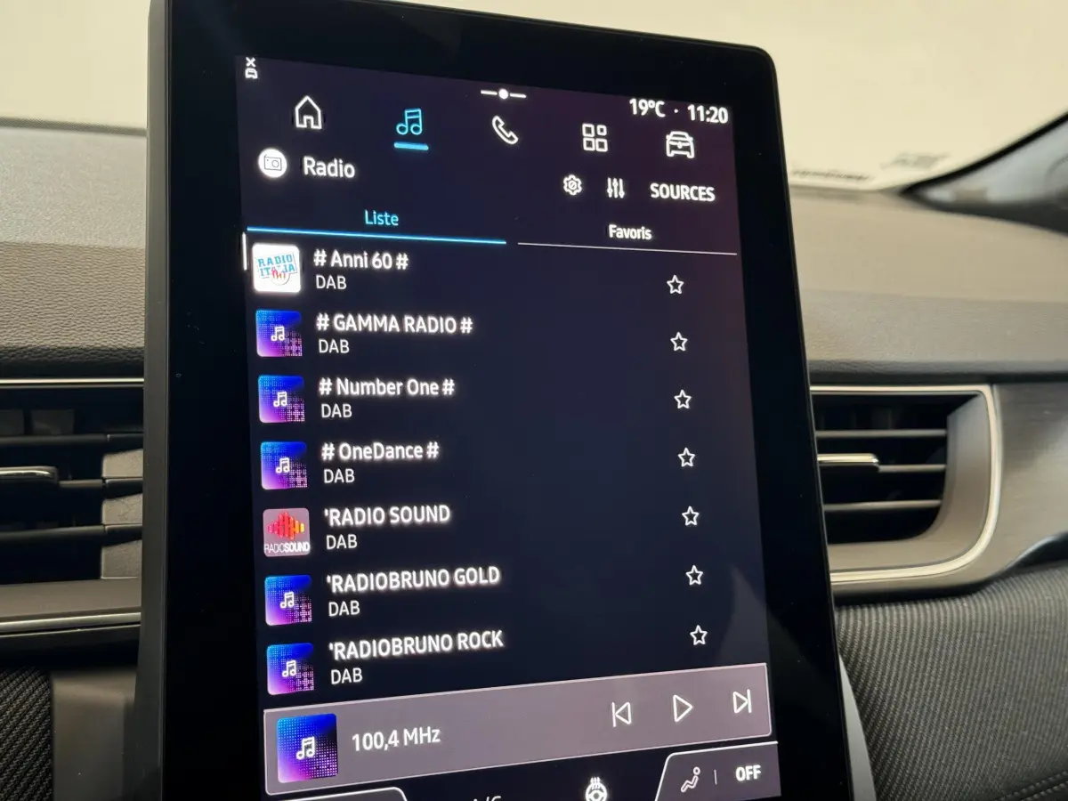 Écran tactile central du tableau de bord du Renault Captur blanc esprit Alpine E-Tech 2025 affichant les radios DAB.
