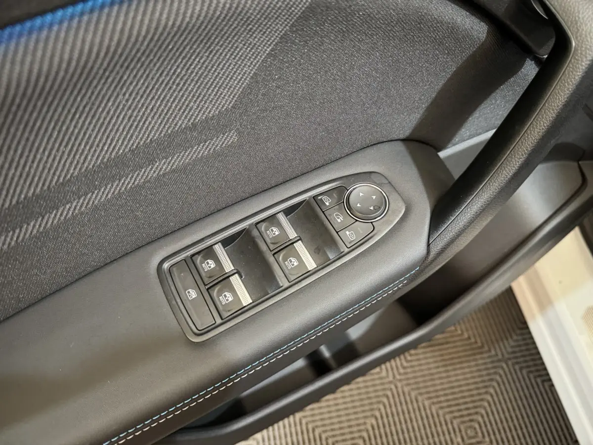 Gros plan sur la commande des vitres et rétroviseurs côté gauche d'une Renault Captur blanc esprit Alpine E-Tech.