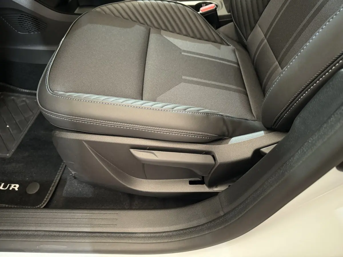 Gros plan sur le siège avant droit noir du Renault Captur Esprit Alpine E-Tech blanc, avec coutures apparentes et moquette noire.