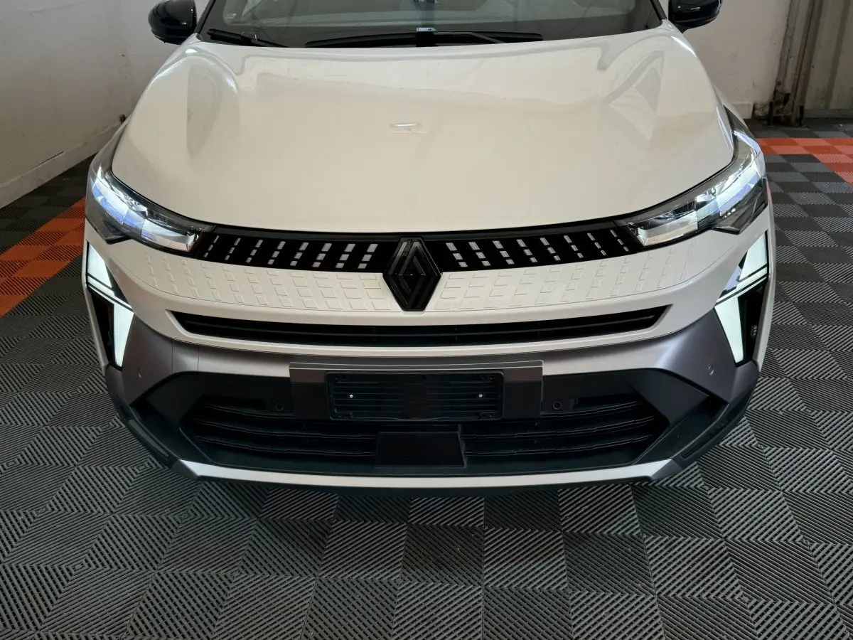 Vue frontale rapprochée du Renault Captur blanc esprit Alpine E-Tech 2025 avec calandre noire et feux LED distinctifs.