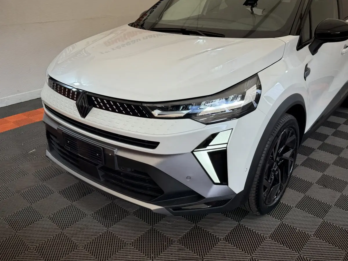 Vue 3/4 avant droit du Renault Captur blanc esprit Alpine E-Tech avec phares LED et calandre noire distinctive.