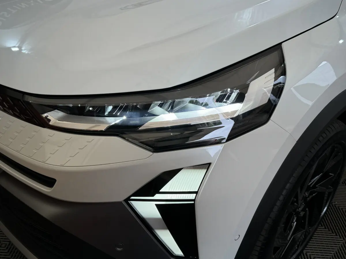 Gros plan sur le phare avant droit blanc du Renault Captur esprit Alpine E-Tech 2025 avec signature lumineuse LED distinctive.