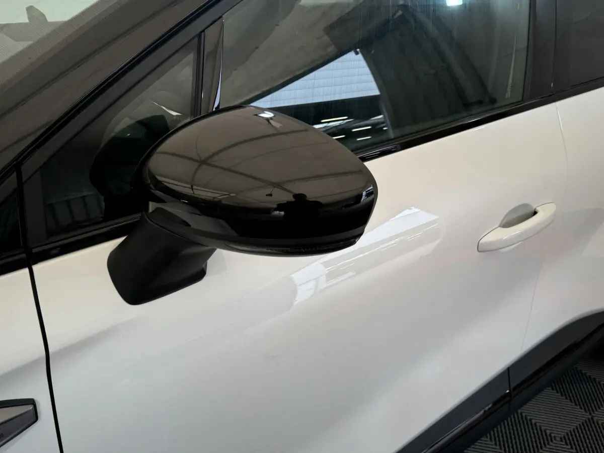 Gros plan sur le rétroviseur noir côté gauche d'un Renault Captur blanc esprit Alpine E-Tech 2025.