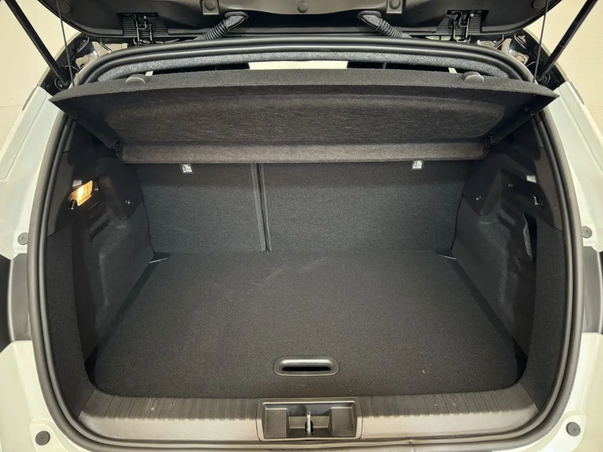 Coffre ouvert du Renault Captur blanc esprit Alpine E-Tech 2025, vue arrière montrant l'espace de chargement vide.