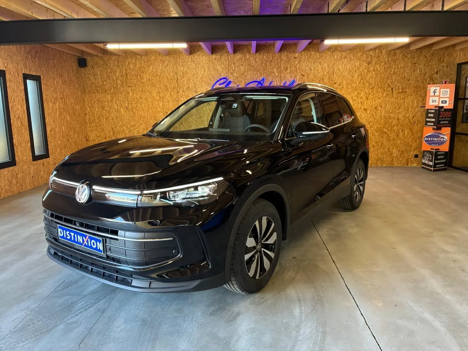 Volkswagen Tiguan 1.5 TSI noir grenadilla métal en 3/4 avant droit dans un showroom intérieur.