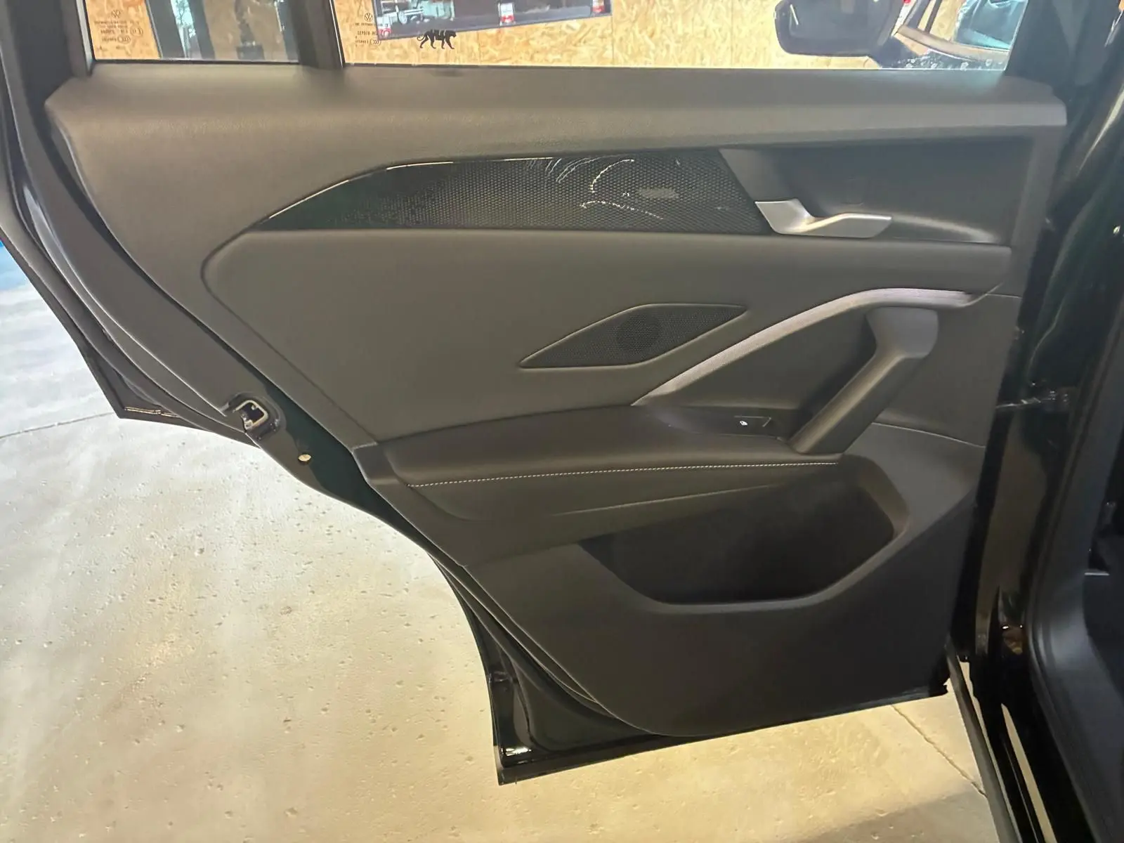 Vue rapprochée de la porte arrière gauche noire Grenadilla métal du Volkswagen Tiguan 2026 avec garniture intérieure noire.