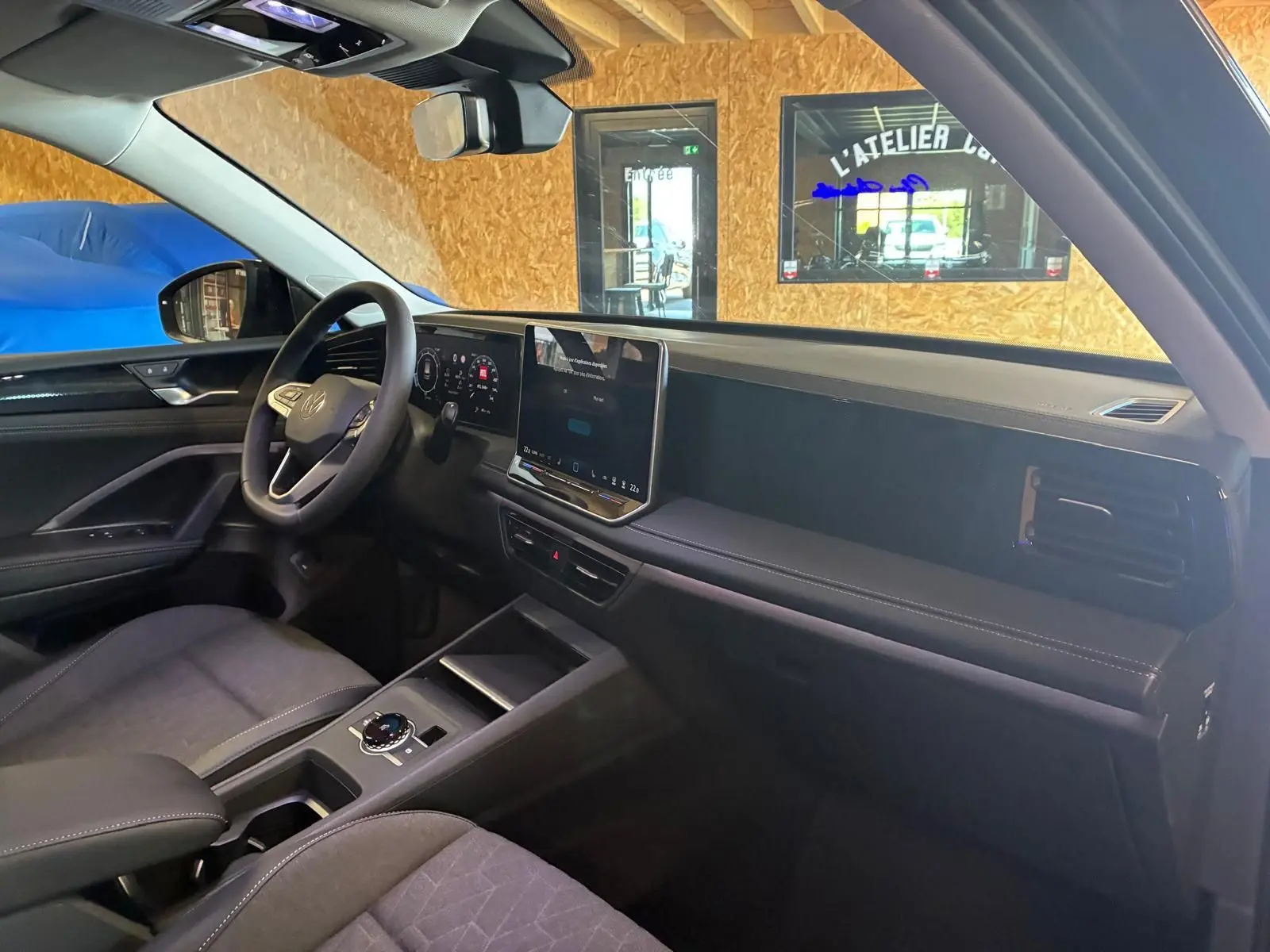 Vue intérieure côté conducteur du Volkswagen Tiguan 2026 noir Grenadilla, avec tableau de bord numérique et écran tactile central.