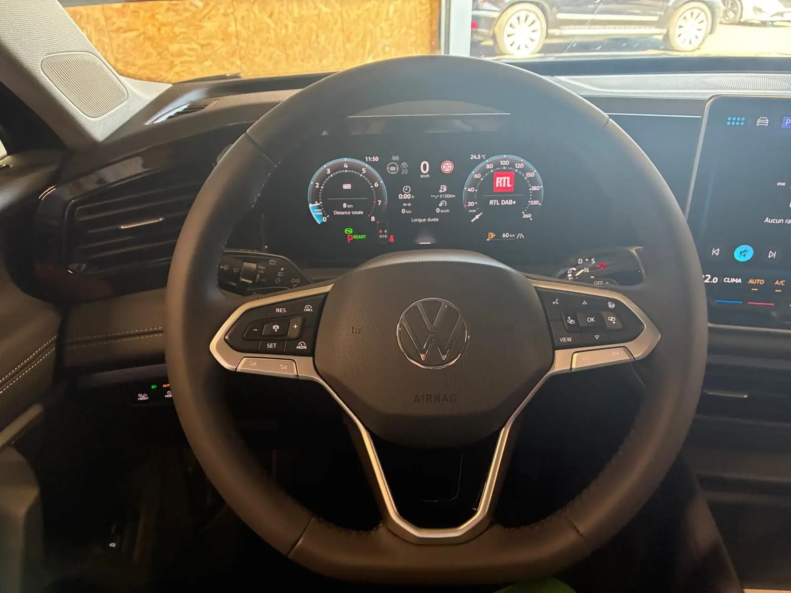 Vue intérieure centrée sur le volant multifonction du Volkswagen Tiguan 2026 avec tableau de bord numérique allumé.