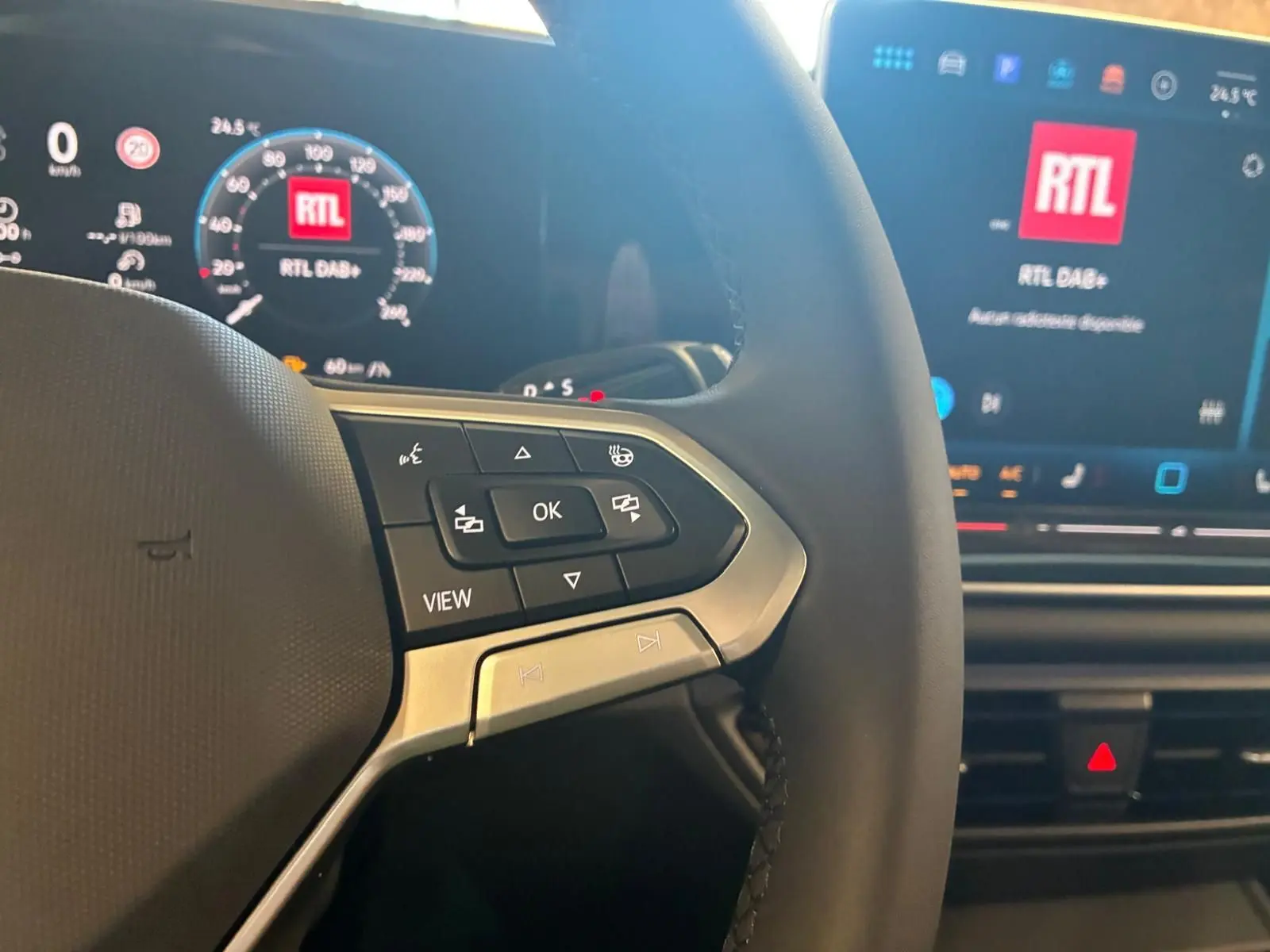 Gros plan sur le volant noir du Volkswagen Tiguan 2026 avec commandes multifonctions et tableau de bord digital lumineux.