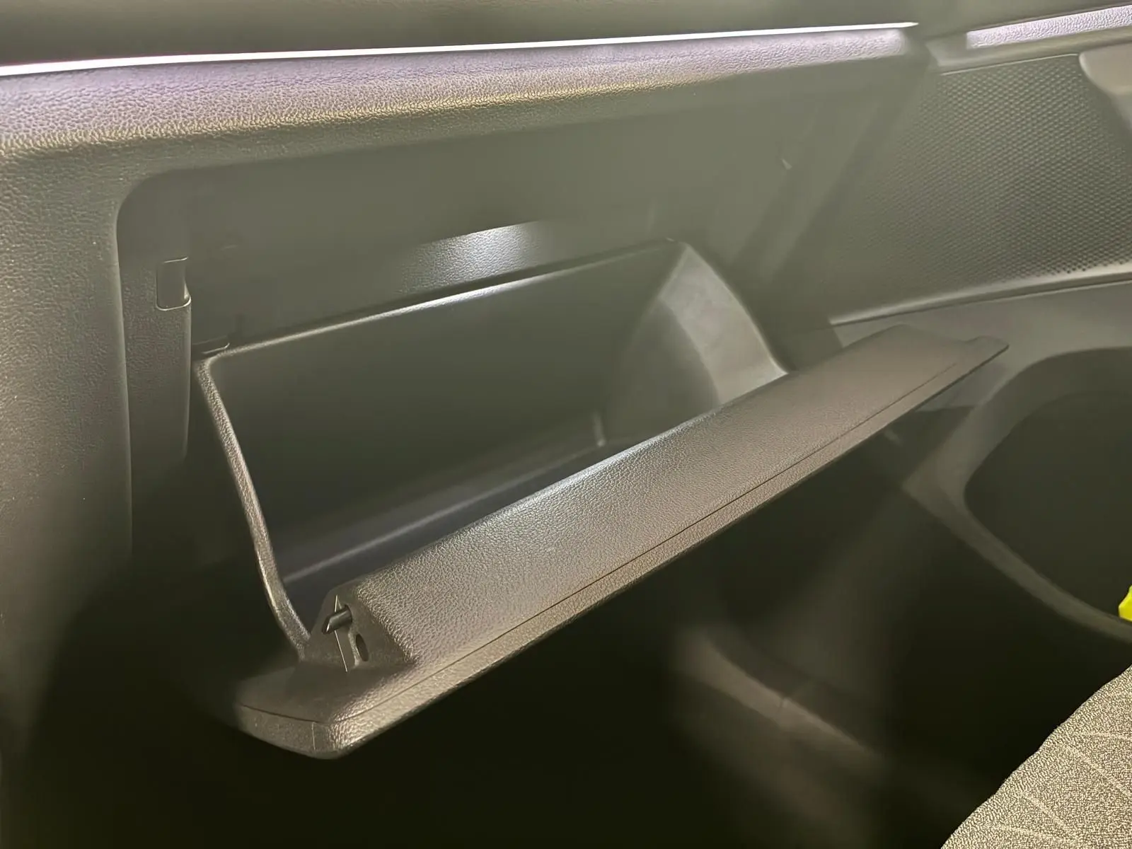 Vue intérieure du Volkswagen Tiguan 2026 noir Grenadilla, boîte à gants ouverte côté passager.
