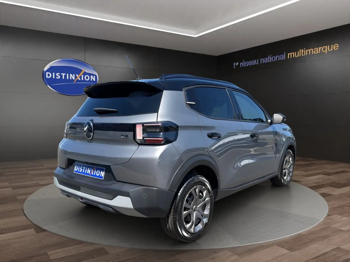 Vue 3/4 arrière droite d'une Citroën C3 hybride gris foncé avec toit noir et feux arrière LED distinctifs.