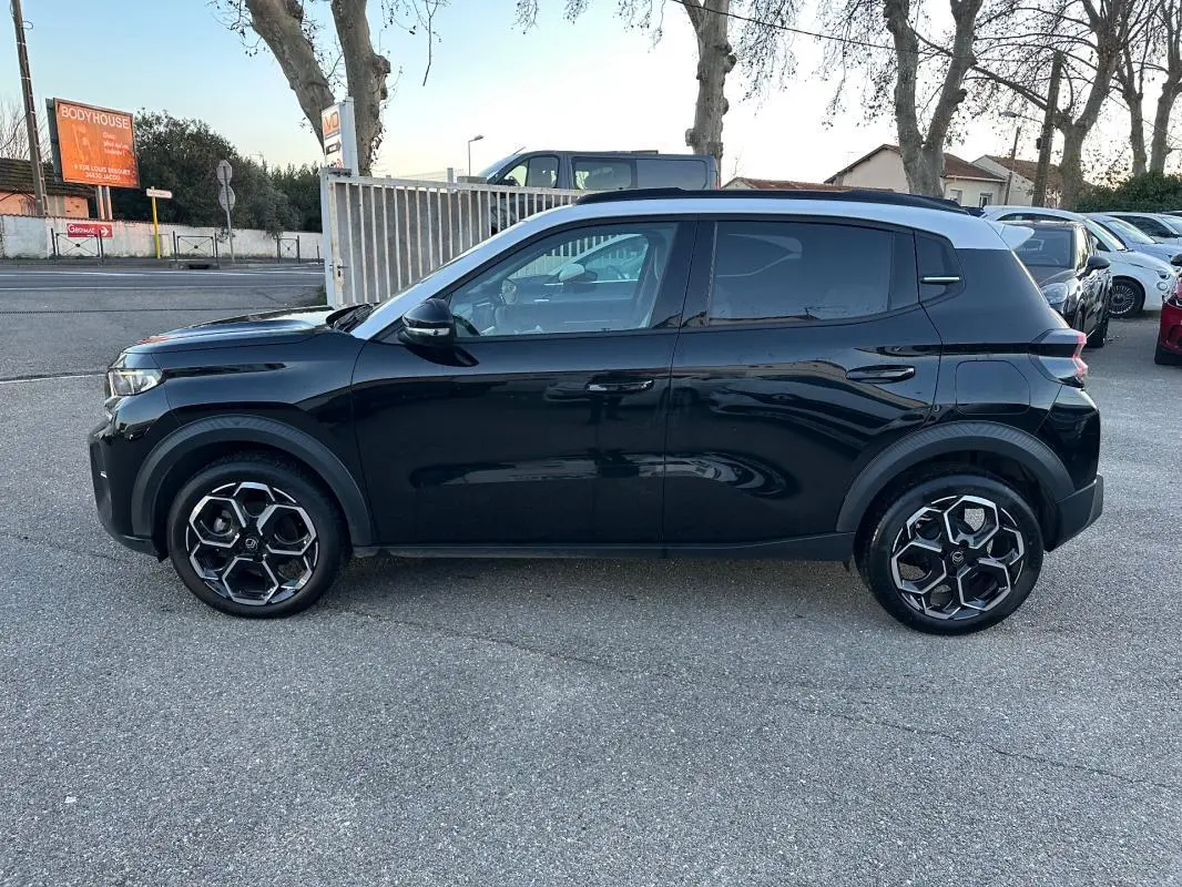 Profil côté gauche d'une Citroën C3 noire 2025 avec jantes alliage 17 pouces et barres de toit visibles.