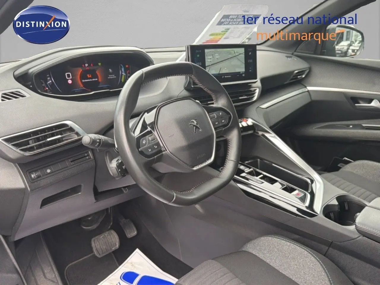 Intérieur avant du Peugeot 5008 Hybrid 2024, vue côté conducteur, tableau de bord numérique et volant compact noir.